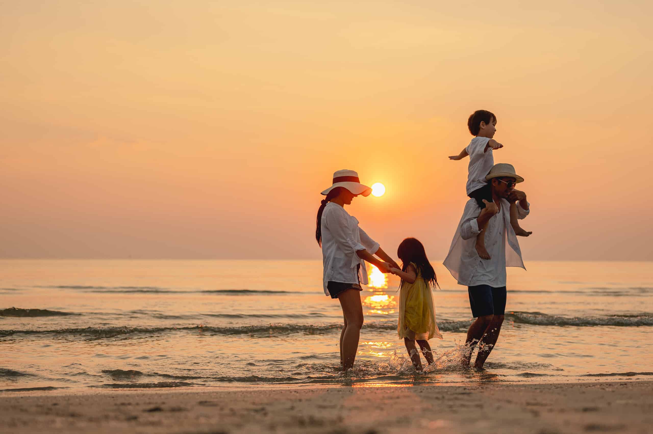 A family on the beach during sunset.